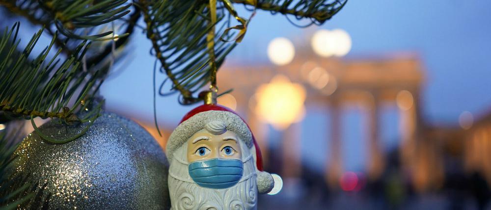 Weihnachtsmann mit Mundschutz vor dem Brandenburger Tor in Berlin