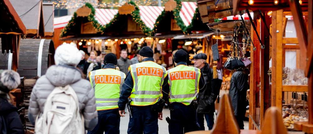 Berlin 2018: Drei Polizisten patrouillieren auf dem Weihnachtsmarkt am Breitscheidplatz.