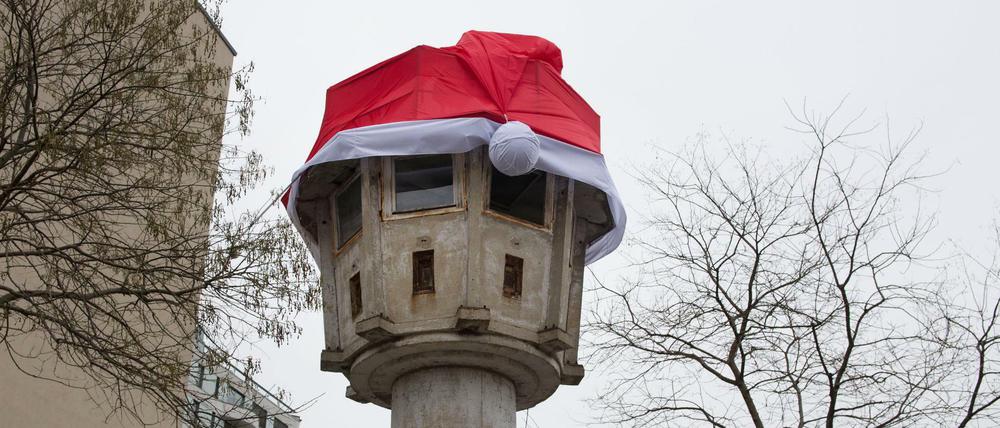 Eine rote Weihnachtsmütze ist auf dem Dach eines ehemaligen DDR-Grenzwachturms am Potsdamer Platz zu sehen.