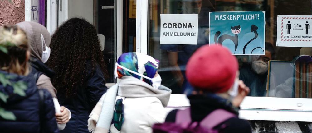 Menschen stehen in einer langen Schlange vor einer Arztpraxis im Bezirk Neukölln für einen Corona-Test an.