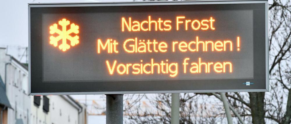 "Nachts Frost - Mit Glätte rechnen! - Vorsichtig fahren" steht auf einer Infotafel in Berlin.
