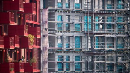 Ein Baugerüst steht an einem Rohbau neben bereits fertiggestellten Neubau-Wohnungen in Kreuzberg.