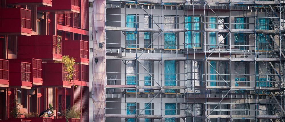 Ein Baugerüst steht an einem Rohbau neben bereits fertiggestellten Neubau-Wohnungen in Kreuzberg.
