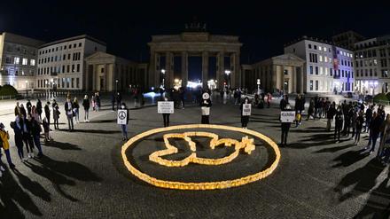 Eine Friedenstaube aus LED-Lichtern und ein dunkles Berliner Wahrzeichen - "Earth Hour" am Brandenburger Tor.