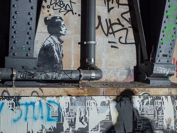 Der Street-Art-Künstler XOOOOX als Schatten vor einer seiner Arbeiten in Berlin-Mitte.