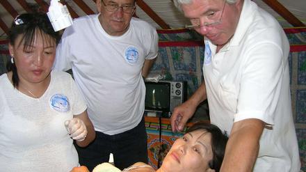 SPRECHSTUNDE IM ZELT. Zahnarzt Wolfgang Credner (rechts), eine mongolische Ärztin (links) sowie Claus Macher (Mitte), Stifter und Präsident des DWLF, mit einer Patientin.