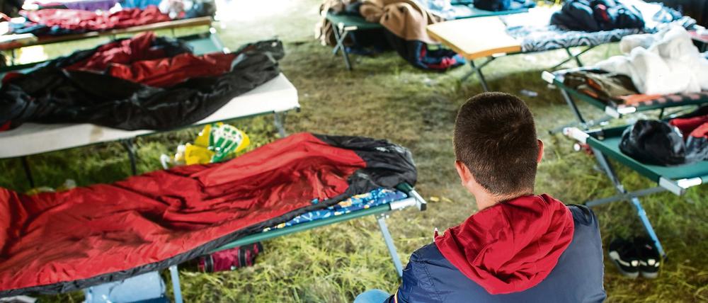 Ein 31 Jahre alter Asylbewerber aus Albanien, der nicht erkannt werden möchte, sitzt auf einer Liege in einem Gruppenzelt in der Zentralen Erstaufnahmestelle Brandenburgs in Eisenhüttenstadt.