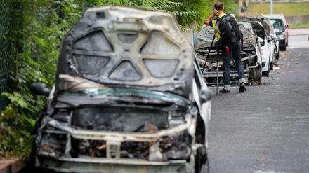 Beamte des Landeskriminalamtes untersuchen ausgebrannte Autos eines Pflegedienstes in Berlin-Steglitz. Insgesamt wurden acht Fahrzeuge angezündet. Foto: Kay Nietfeld/dpa 