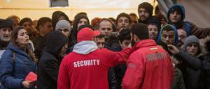 Mitarbeiter eines Sicherheitsdienstes organisieren vor dem Landesamt für Gesundheit und Soziales (LaGeSo) in Berlin den Einlass. Täglich stehen bereits frühmorgens zahlreiche Flüchtlinge zur Registrierung oder zur Beantragung von Leistungen vor dem Amt (Archivbild). 
