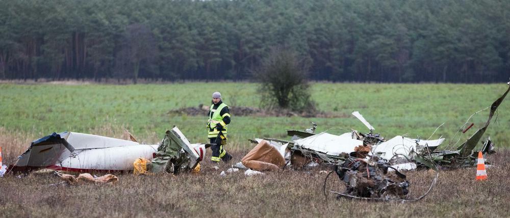 Die Trümmer eines Flugzeugs liegen nach einem Absturz auf einem Feld verstreut.