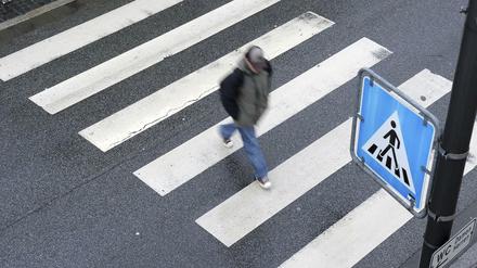 Ein Fußgänger geht über einen Zebrastreifen. (Symbolfoto) 