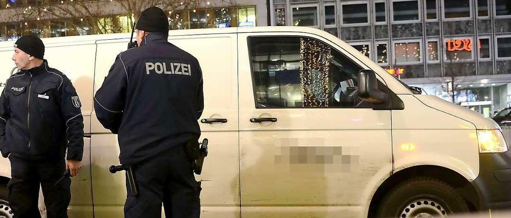 Tatort Taunetzienstraße. Polizisten stehen am 30.12.2013 vor dem überfallenen Geldtransporter. 
