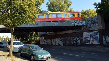 Eine S-Bahn fährt in der Schorfheidestraße nahe dem S-Bahnhof Wilhelmsruh in Berlin über eine Bahnbrücke mit Graffitis. Hier starben zwei junge Männer.