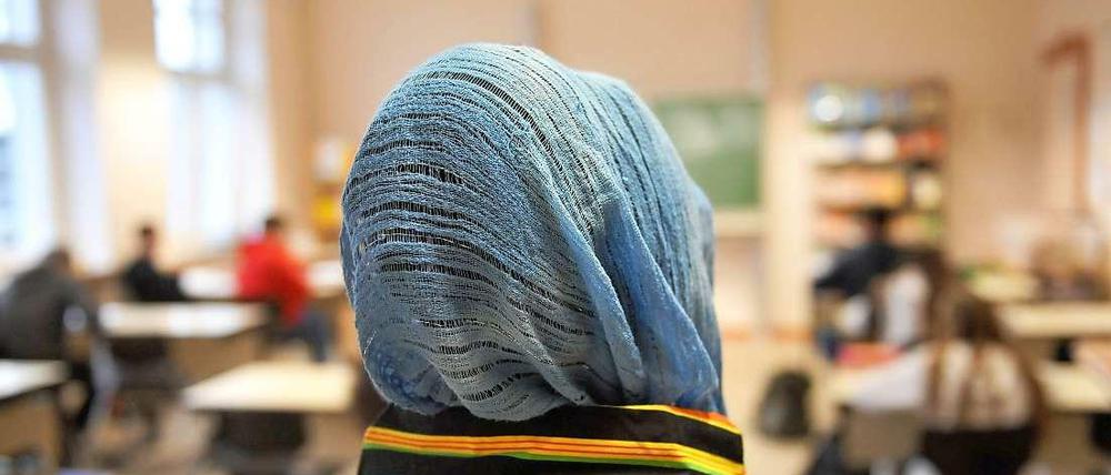 Eine muslimische Schülerin im Unterricht. Das Tragen von Kopfbedeckungen im Unterricht dürfen Schulen nicht verbieten.