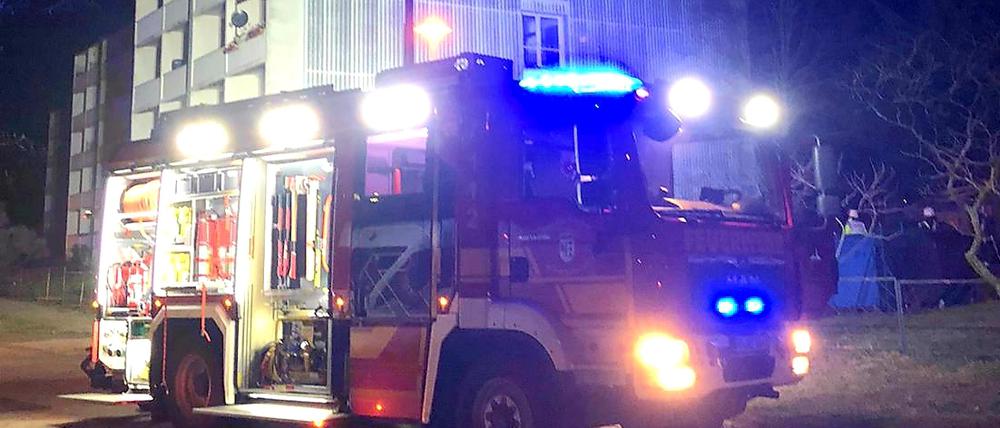 Ein Feuerwehrfahrzeug steht vor dem Mehrfamilienhaus in Werder an der Havel, in dem es in der Nacht zu Heiligabend gebrannt hat.