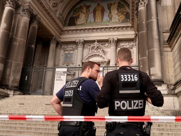 Zwei Polizisten stehen am frühen Sonntagabend vor dem Berliner Dom. Hier war es zu einer Schussabgabe durch einen Polizeibeamten auf einen aggressiven Mann gekommen.