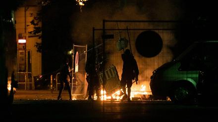Das geschah in der Nacht zu Sonnabend in der Rigaer Straße: Unbekannte werfen Baumaterialien auf eine brennende Barrikade.