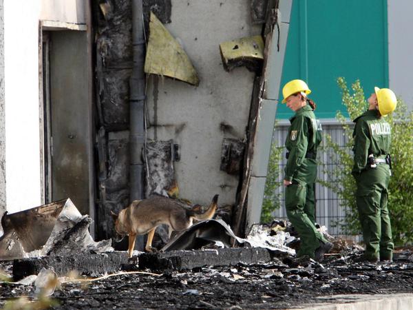 Spürhunde im Einsatz. Experten der Berliner Polizei sind am Mittwoch in Nauen (Brandenburg) vor der abgebrannten Turnhalle im Einsatz. 