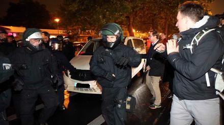 Polizisten schützt AfD-Anhänger, die die Wahlparty in einem Taxi verlassen wollen.