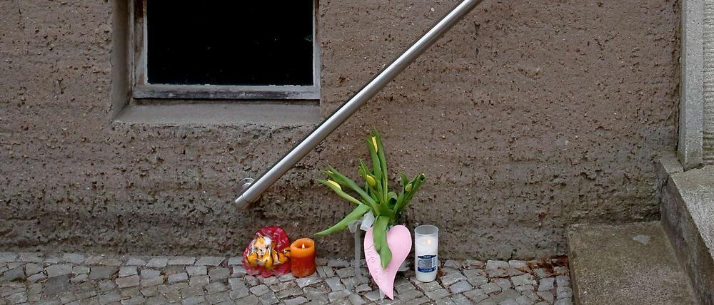 Anwohner haben Blumen und Kerzen vor dem Haus in Erkner abgelegt, wo eine Vierjährige getötet wurde.