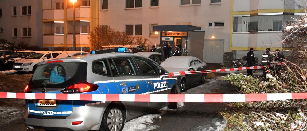 Einsatzkräfte der Polizei und ein Polizeiwagen stehen in Berlin vor einem Wohnhaus an der Ribnitzer Straße. 
