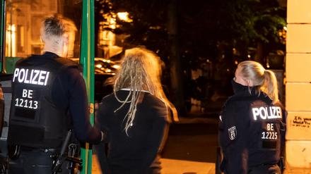 Polizisten führen in der Jessnerstraße eine Person ab. Unbekannte randalierten am Samstagabend in Friedrichshain.