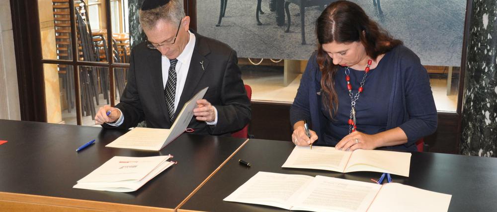 Yossi Gevir, Vertreteter der Gedenkstätte Yad Vashem, und Bildungssenatorin Sandra Scheeres unterzeichnen die gemeinsame Erklärung.