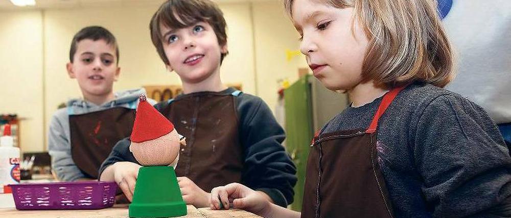 Kritischer Blick. Schüler der Treptower Bouché-Grundschule betrachten ihr Werk, das sie in den Lernwerkstätten in Oberschöneweide gebastelt haben. Foto: Georg Moritz