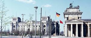 Zwischen 1961 und 1973 wird der Reichstag nach Plänen von Paul Baumgarten wieder aufgebaut, genutzt wurde er allerdings kaum. Bundestagssitzungen waren nach dem Viermächteabkommen von 1971 in Berlin ohnehin nicht zulässig. Nur Fraktions- und Ausschusssitzungen durften im Berliner Reichstag stattfinden. Trotzdem war im Zentrum des Gebäudes ein vollständiger Tagungssaal eingerichtet, der jederzeit den Abgeordneten eines wiedervereinigten Deutschlands hätte Platz bieten können. Auf dem Foto sind der Reichstag und das Brandenburger Tor in den 60er Jahren zu sehen.