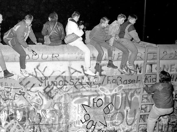 West-Berliner haben die Mauer auf der Westseite des Checkpoint Charlie erklommen. Im Fernsehen haben sie von der Grenzöffnung erfahren. Nun wollen sie die ersten DDR-Bürger begrüßen, die in den Westen kommen. Die DDR-Grenzer sind mit der Situation völlig überfordert.