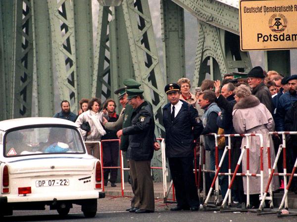 Nach dem Massenansturm vom Wochenende ebbt der Besucherandrang zu Wochenbeginn deutlich ab. Hier kehren DDR-Bürger in einem Trabbi auf der Glienicker Brücke in die DDR zurück.