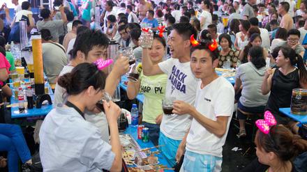Besucher feiern am 16.08.2014 beim Oktoberfest im chinesischen Qingdao.