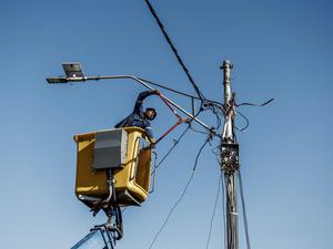 Ein Arbeiter entfernt den illegalen Stromanschluss einer informellen Siedlung in Johannesburg.