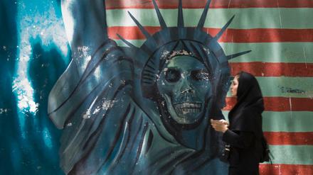 Eine Frau läuft in Teheran an einem Anti-USA-Graffiti vorbei.