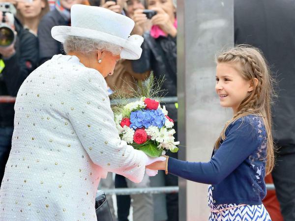 Blumenmädchen Louisa überreicht der Queen einen Strauß.