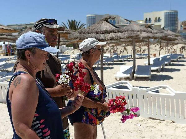Geschockt und ungläubig. Touristen am Tatort des blutigen Geschehens am Strand von Sousse.