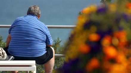 Ein übergewichtiger, älterer Mann sitzt auf einer Bank. (Archivbild, 15.06.2012)