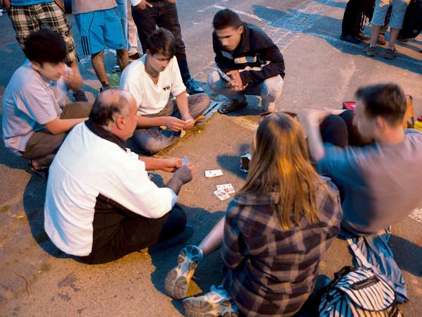 Asylsuchende vertreiben sich die Zeit mit Kartenspielen in der Nähe des Baumarktes in Heidenau in dem sie untergebracht sind. 