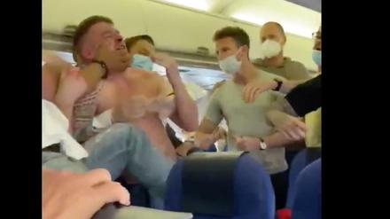 Flugpassagiere eines KLM-Flugs streiten sich wegen der Maskenpflicht. 