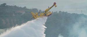 Ein Canadair-Flugzeug wirft Wasser ab, um ein Feuer in der Nähe von Oristano auf der Insel Sardinien zu löschen. 