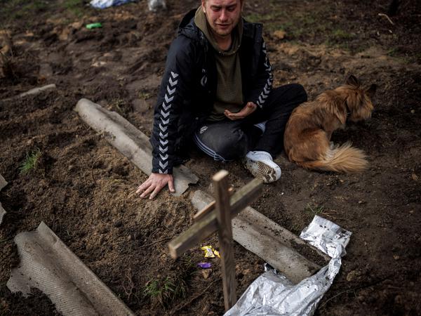 Ein Mann betrauert nach dem Massaker in Butscha einen von russischen Soldaten getöteten Freund an dessen Grab.