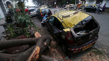 Ein beschädigtes Fahrzeug neben einem umgestürzten Baum nach starken Winden, die durch den Zyklon Tauktae in Mumbai, Indien, verursacht wurden.