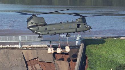 Ein RAF CH-47 Chinook Hubschrauber trägt Sandsäcke, um den Staudamm am Toddbrook nahe Whaley Bridge zu verstärken. 