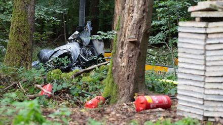 Trümmerteile eines Hubschraubers vom Typ Robinson R44 und Feuerlöscher liegen in einem Wald nahe der Grenze zu Hessen und Bayern. 