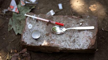 Drogenbesteck eines Fixers - Einwegspritze und Löffel wurden nach dessen Gebrauch auf einem Stein hinterlassen.
