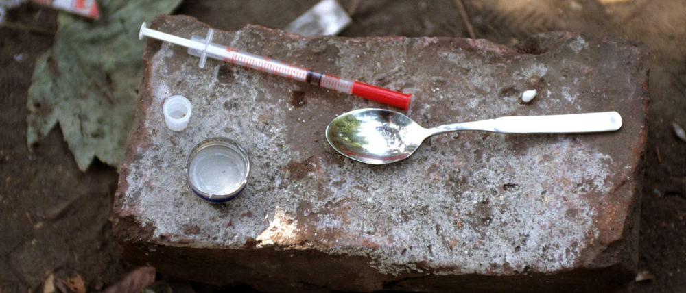 Drogenbesteck eines Fixers - Einwegspritze und Löffel wurden nach dessen Gebrauch auf einem Stein hinterlassen.