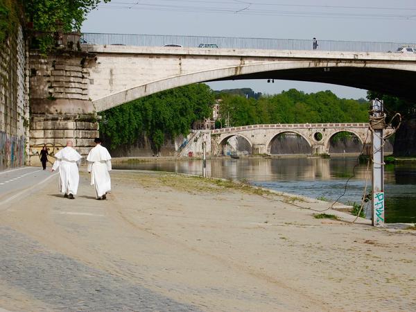 Beobachtungen am Fluss: Mönche spazieren am Tiber-Radweg entlang.