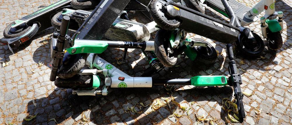 Umgestürzte E-Roller liegen auf einem Gehweg in Berlin.