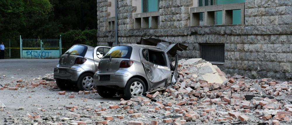 Zwei beschädigte Autos liegen nach einem Erdbeben vor dem Gebäude der Geologie-Fakultät in Tirana.