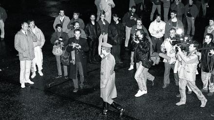 Historisches Momentum. Ein Grenzsoldat der DDR geht am 9. November 1989 in Ost-Berlin zur Mauer, beobachtet von Passanten, Fotografen, Hörfunk- und Fernsehreportern, darunter Teams des Senders Freies Berlin. 